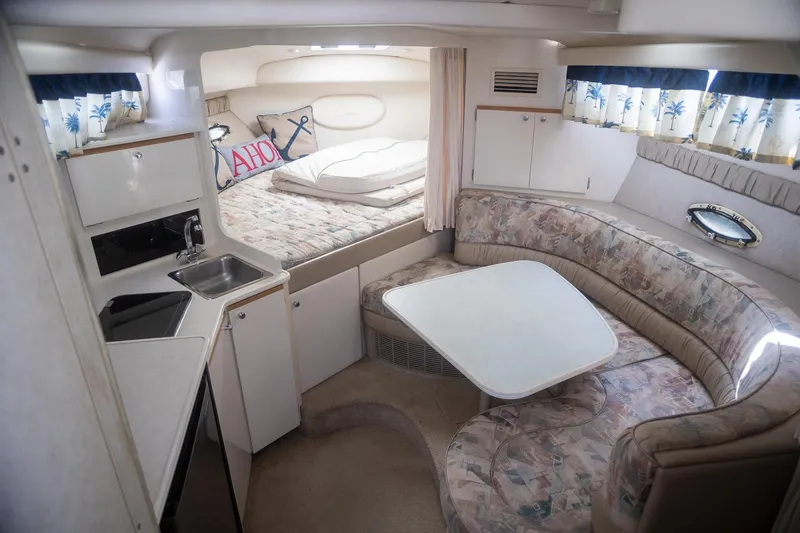Slide: The Image of 1999 Bayliner 3055 Ciera Sunbridge interior with kitchenette, bed, and seating area. - 16