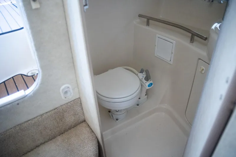 Slide: The Image of 1999 Bayliner 3055 Ciera Sunbridge boat bathroom with compact toilet and handrail. - 17