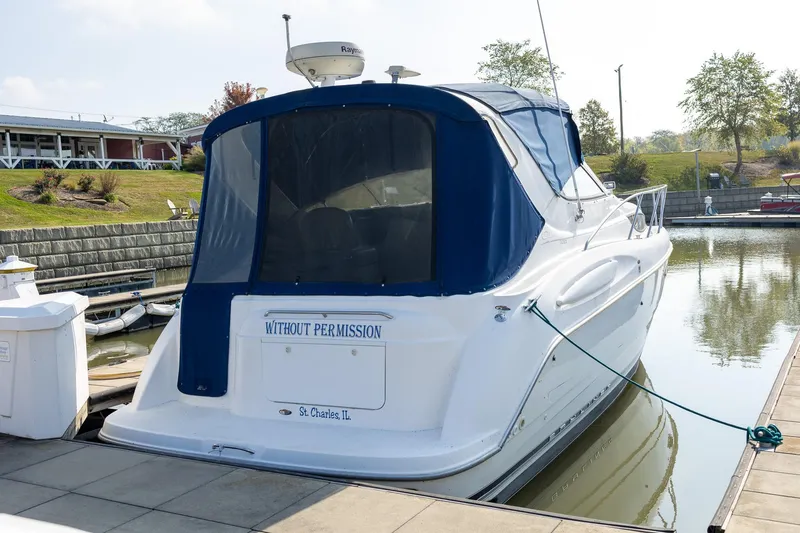 Slide: The Image of 1999 Bayliner 3055 Ciera Sunbridge docked, featuring blue canopy and "Without Permission" name. - 2