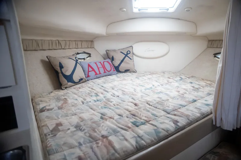 Slide: The Image of 1999 Bayliner 3055 Ciera Sunbridge cabin with cozy bedding and nautical-themed pillows. - 21