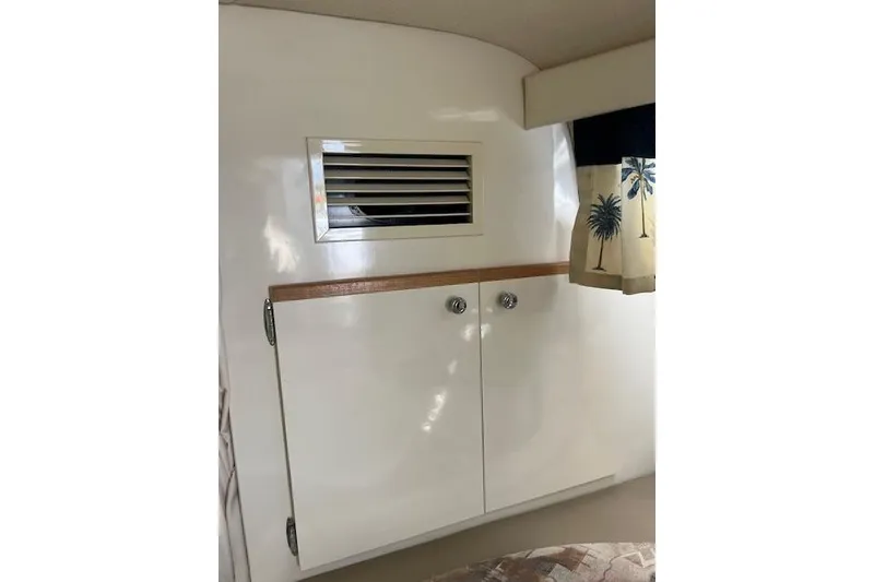 Slide: The Image of Interior of 1999 Bayliner 3055 Ciera Sunbridge with cabinet and tropical curtains. - 24