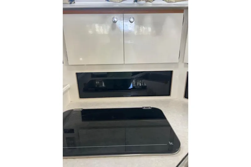 Slide: The Image of 1999 Bayliner 3055 Ciera Sunbridge interior kitchen with cabinets and stove. - 26