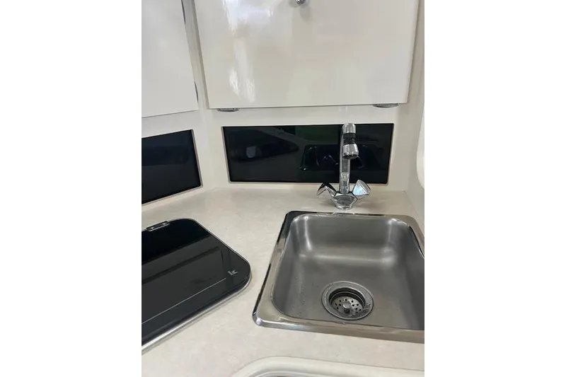 Slide: The Image of 1999 Bayliner 3055 Ciera Sunbridge kitchen sink and counter area. - 28