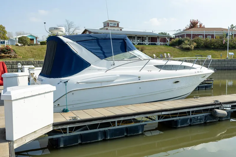 Slide: The Image of 1999 Bayliner 3055 Ciera Sunbridge docked at a marina with blue canopy. - 3