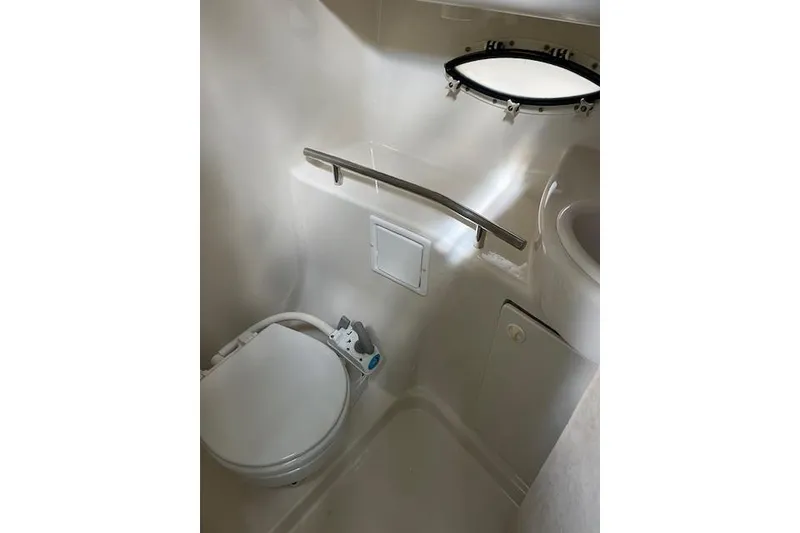Slide: The Image of Bathroom interior of 1999 Bayliner 3055 Ciera Sunbridge with toilet and porthole window. - 33