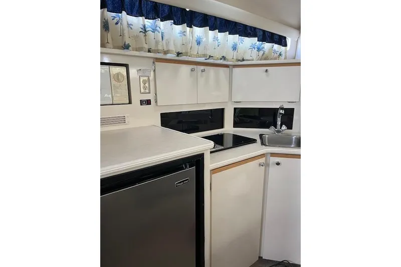 Slide: The Image of Interior of a 1999 Bayliner 3055 Ciera Sunbridge boat kitchen with cabinets and appliances. - 34