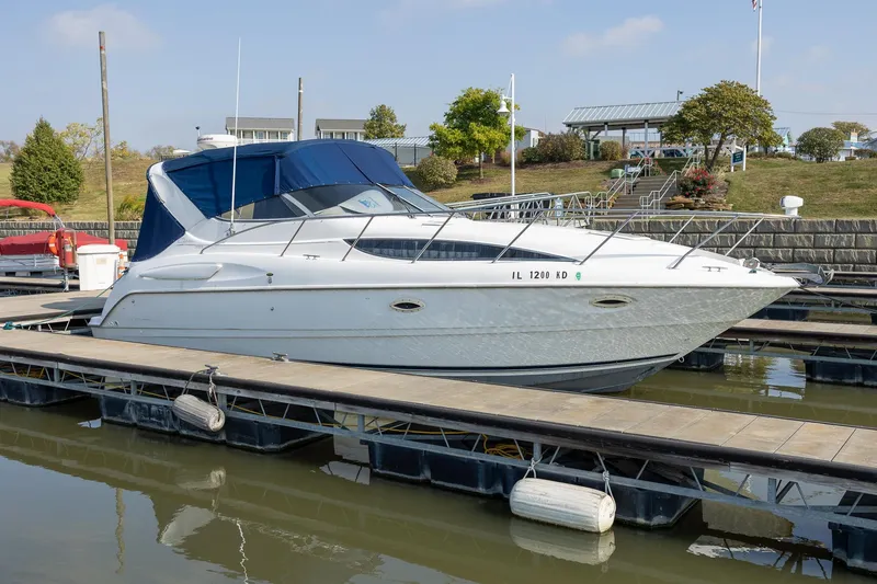 Slide: The Image of 1999 Bayliner 3055 Ciera Sunbridge docked at marina with blue canopy. - 4