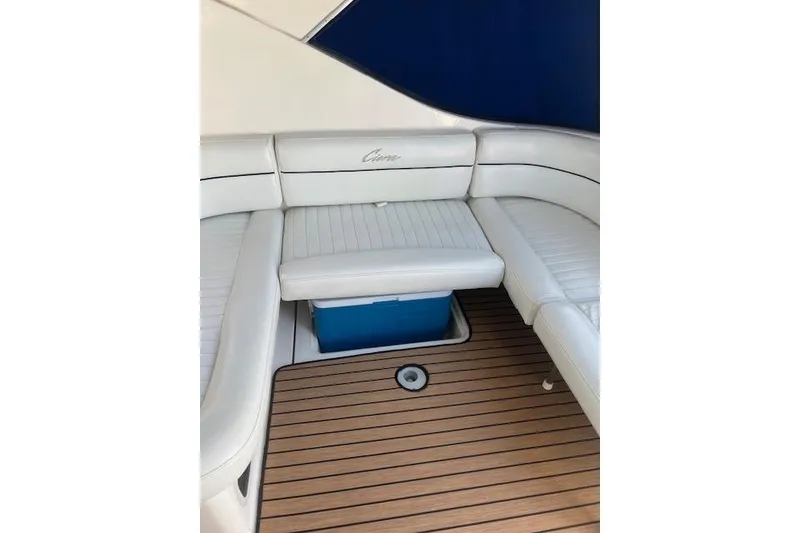 Slide: The Image of 1999 Bayliner 3055 Ciera Sunbridge interior with white seating and wooden deck. - 6