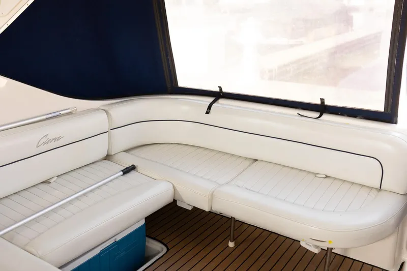 Slide: The Image of 1999 Bayliner 3055 Ciera Sunbridge interior with white seating and wooden flooring. - 7