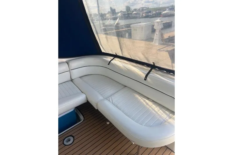 Slide: The Image of 1999 Bayliner 3055 Ciera Sunbridge interior with white seating and wooden deck. - 8