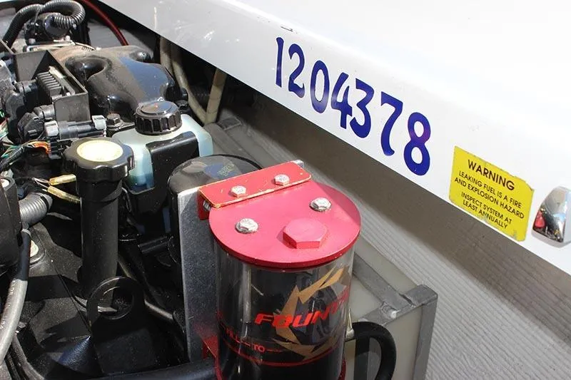 Slide: The Image of Engine compartment of 2000 Fountain 32 Fever boat with visible components and warning label. - 23