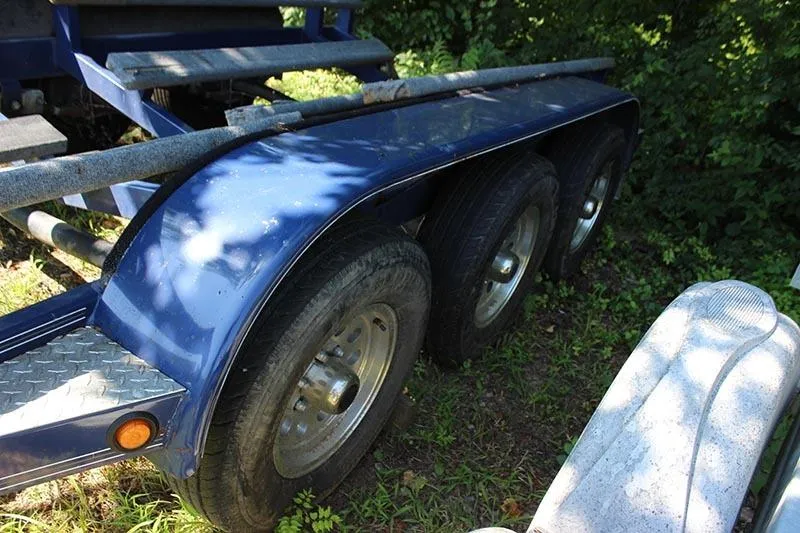 Slide: The Image of Triple-axle trailer for 2000 Fountain 32 Fever boat, parked on grass. - 25
