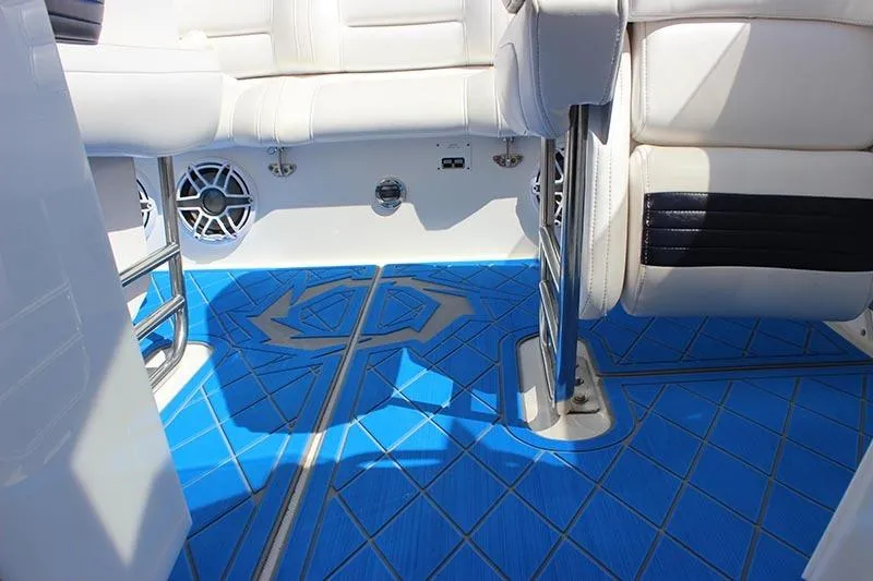 Slide: The Image of Interior of 2000 Fountain 32 Fever boat with blue patterned flooring and white seating. - 30