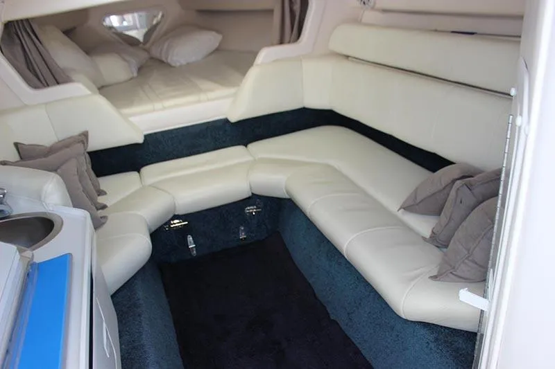 Slide: The Image of Interior of 2000 Fountain 32 Fever boat with white leather seating and cozy sleeping area. - 48