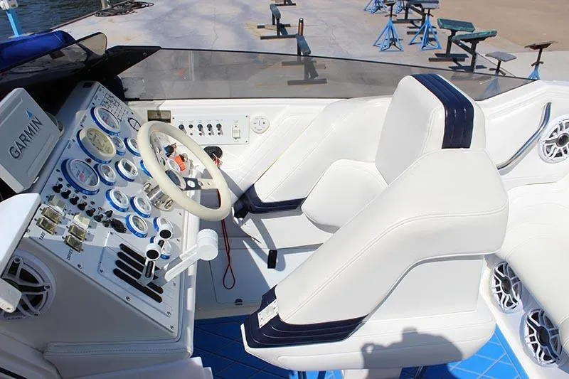 Slide: The Image of Cockpit of 2000 Fountain 32 Fever boat with white seating and Garmin navigation system. - 5