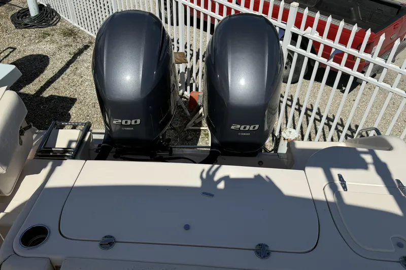Slide: The Image of 2014 Grady-White Freedom 275 boat with twin Yamaha 200 engines, parked near a white fence. - 12