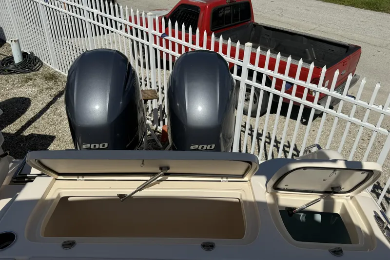 Slide: The Image of 2014 Grady-White Freedom 275 boat with dual 200 horsepower engines, parked near a red truck. - 13