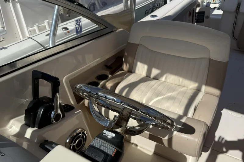 Slide: The Image of 2014 Grady-White Freedom 275 boat cockpit with steering wheel and captain's chair. - 22