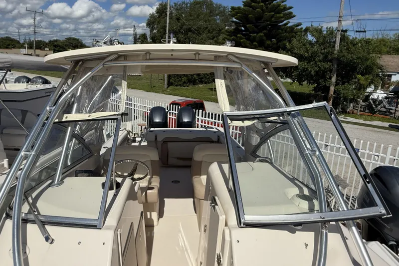 Slide: The Image of 2014 Grady-White Freedom 275 boat with open cockpit and dual engines, docked outdoors. - 30