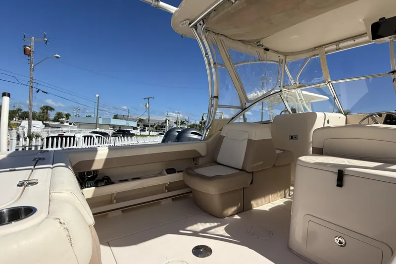 Slide: The Image of 2014 Grady-White Freedom 275 boat interior with seating and canopy under clear blue sky. - 37