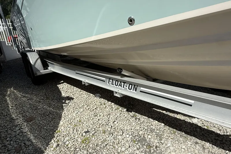 Slide: The Image of 2014 Grady-White Freedom 275 boat on a Float-On trailer, parked on gravel. - 38