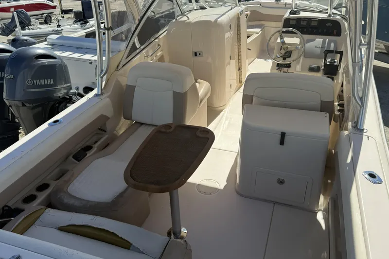 Slide: The Image of 2014 Grady-White Freedom 275 boat interior with seating, table, and Yamaha outboard motor. - 9