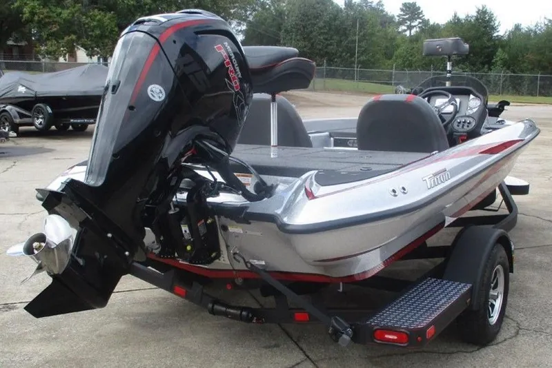 Slide: The Image of 2026 Triton 179 TrX boat with powerful outboard motor, parked on a trailer. - 3