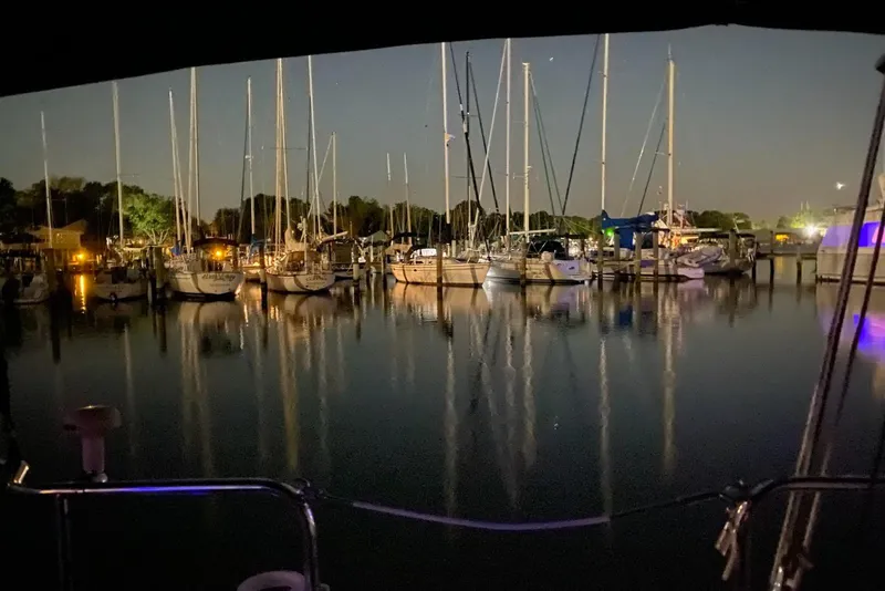 Slide: The Image of Nighttime marina with sailboats, including a 2006 Catalina 309, reflecting on calm water. - 0