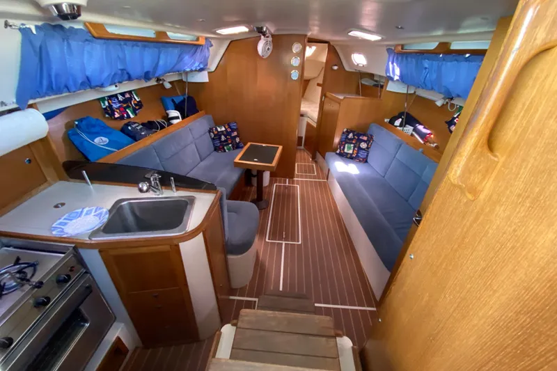 Slide: The Image of Interior of 2006 Catalina 309 sailboat with cozy seating and compact kitchen area. - 16