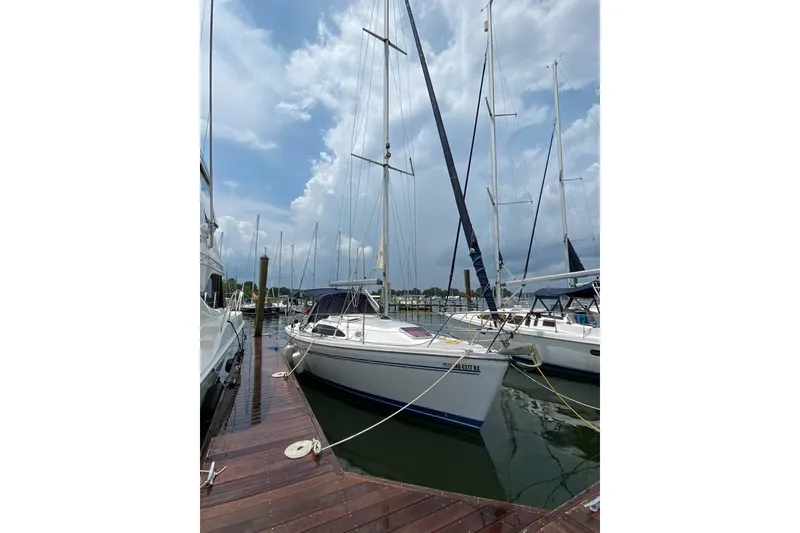 Slide: The Image of 2006 Catalina 309 sailboat docked at marina under cloudy sky. - 2