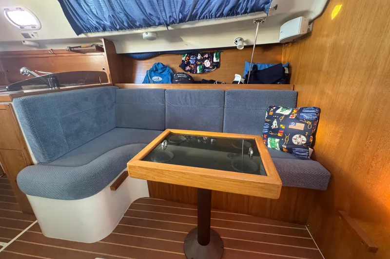 Slide: The Image of Cozy interior of 2006 Catalina 309 sailboat with blue seating and wooden table. - 29