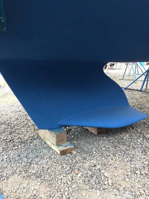 Slide: The Image of Catalina 309 sailboat keel, 2006 model, resting on wooden blocks, gravel ground. - 3