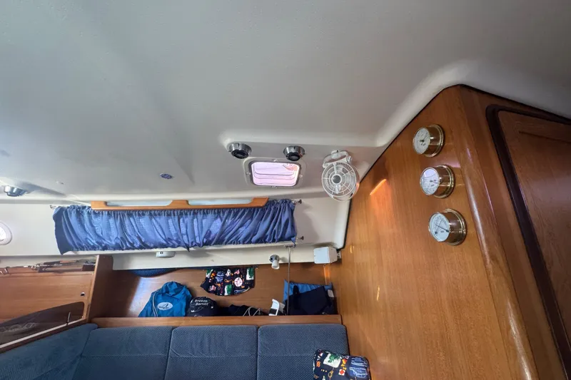 Slide: The Image of Interior of 2006 Catalina 309 sailboat with blue curtains and wooden paneling. - 30