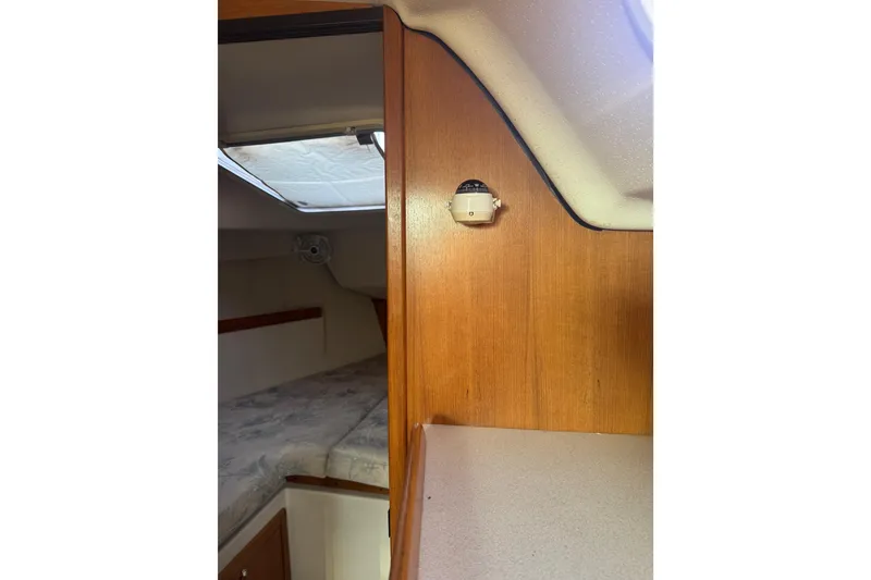 Slide: The Image of Interior cabin of a 2006 Catalina 309 sailboat with wood paneling and a cozy berth. - 31