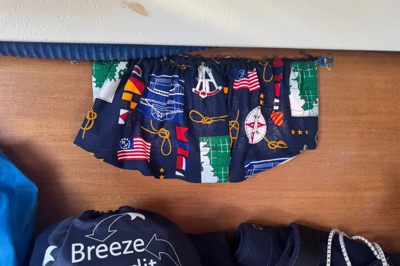 Slide: The Image of Curtain with nautical design inside a 2006 Catalina 309 sailboat cabin. - 33