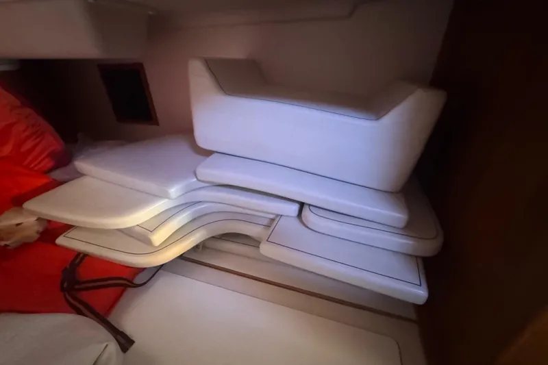Slide: The Image of Stacked white cushions inside a 2006 Catalina 309 sailboat cabin. - 38