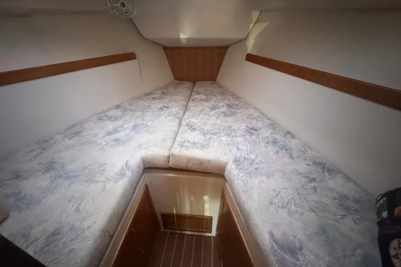 Slide: The Image of 2006 Catalina 309 yacht interior cabin with twin beds and wooden accents. - 45