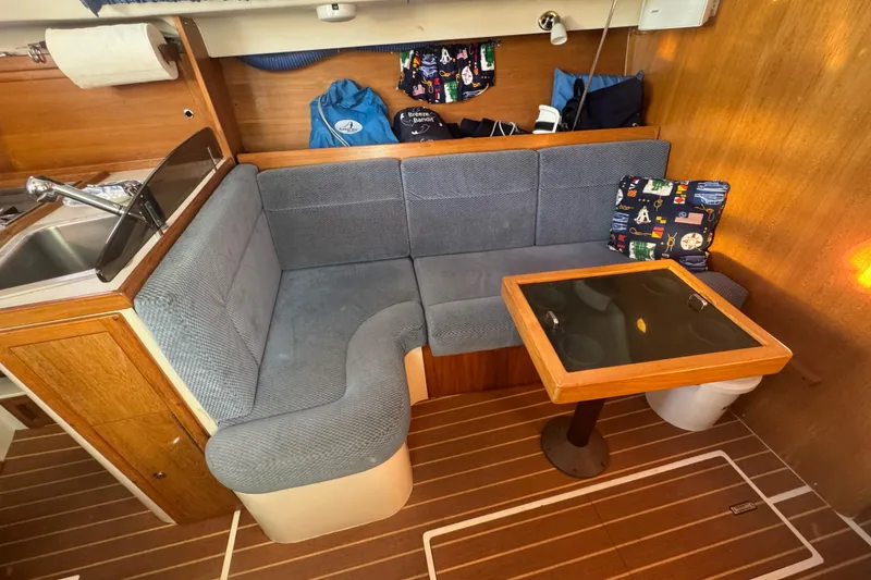 Slide: The Image of Cozy interior of 2006 Catalina 309 sailboat with cushioned seating and wooden table. - 48