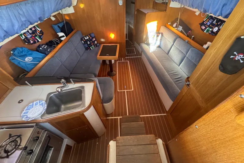 Slide: The Image of Interior of 2006 Catalina 309 sailboat with cozy seating and compact kitchen area. - 51