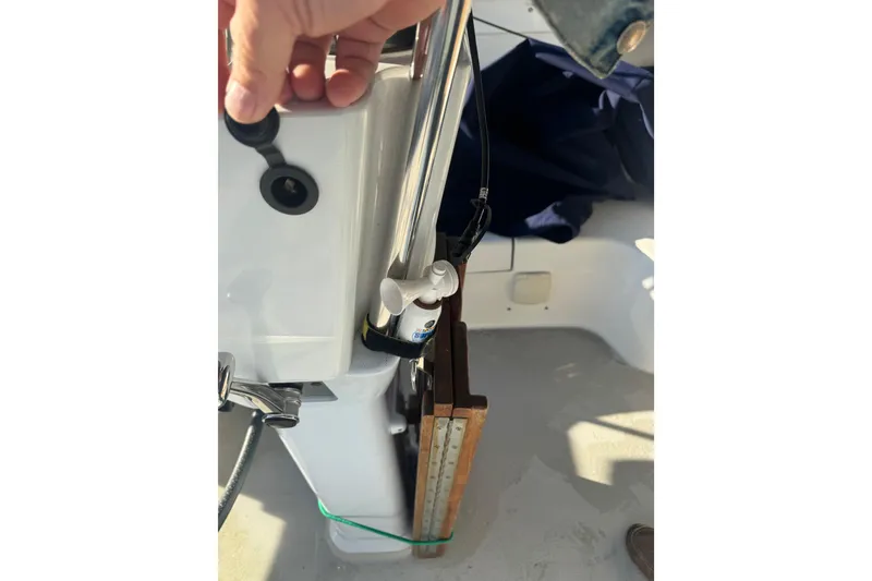 Slide: The Image of Close-up of a 2006 Catalina 309 sailboat cockpit with hand on control panel. - 52