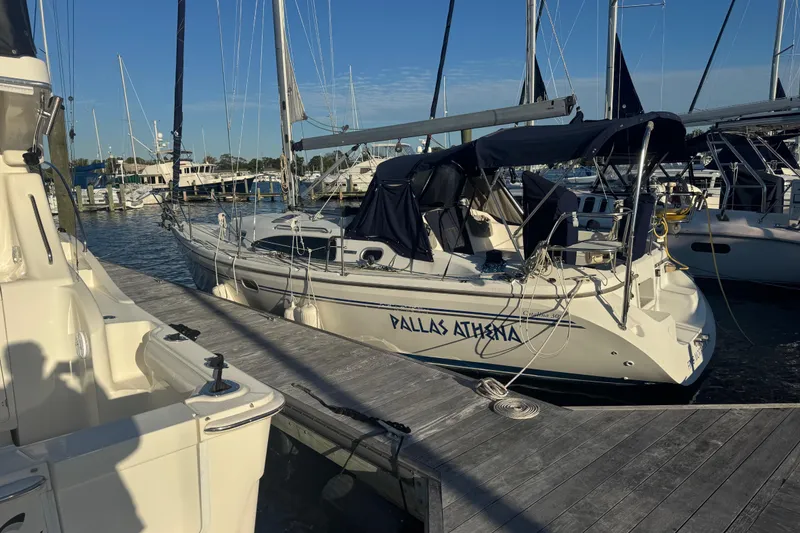 Slide: The Image of 2006 Catalina 309 sailboat docked at marina, named "Pallas Athena." - 63