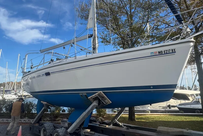 Slide: The Image of 2006 Catalina 309 sailboat on trailer, marina background, clear sky. - 69