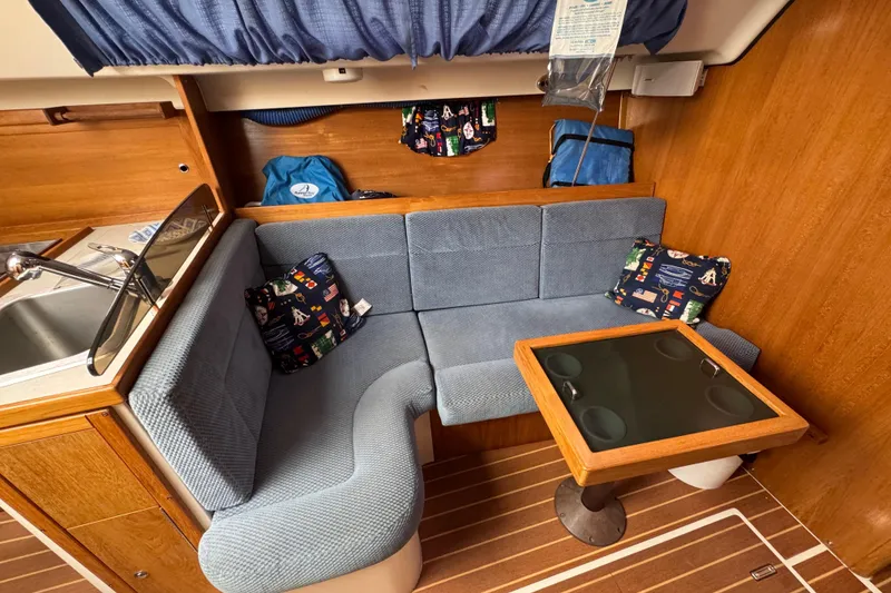 Slide: The Image of Interior of a 2006 Catalina 309 sailboat with cozy seating and a compact table. - 72