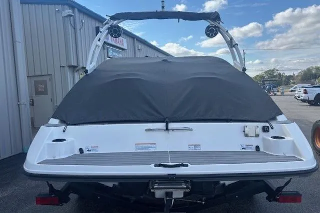 Slide: The Image of 2020 Yamaha AR210 boat with cover, parked outdoors near a building. - 6