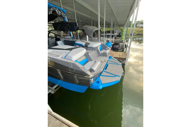Slide: The Image of 2022 Nautique Super Air Nautique G23 cruising on a calm lake. - 2