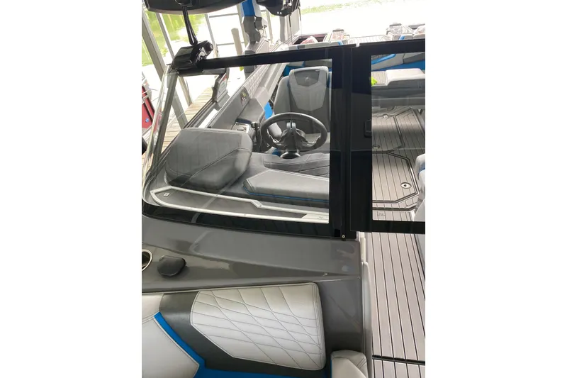 Slide: The Image of 2022 Nautique Super Air Nautique G23 boat on a calm lake with autumn trees. - 9