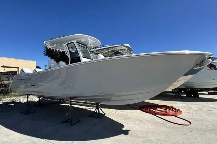 Slide: The Image of 2026 Sportsman Heritage 261 Center Console boat on display under clear blue sky. - 0