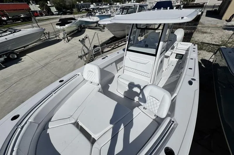 Slide: The Image of 2026 Sportsman Heritage 261 Center Console boat, sleek design, docked in a marina. - 12