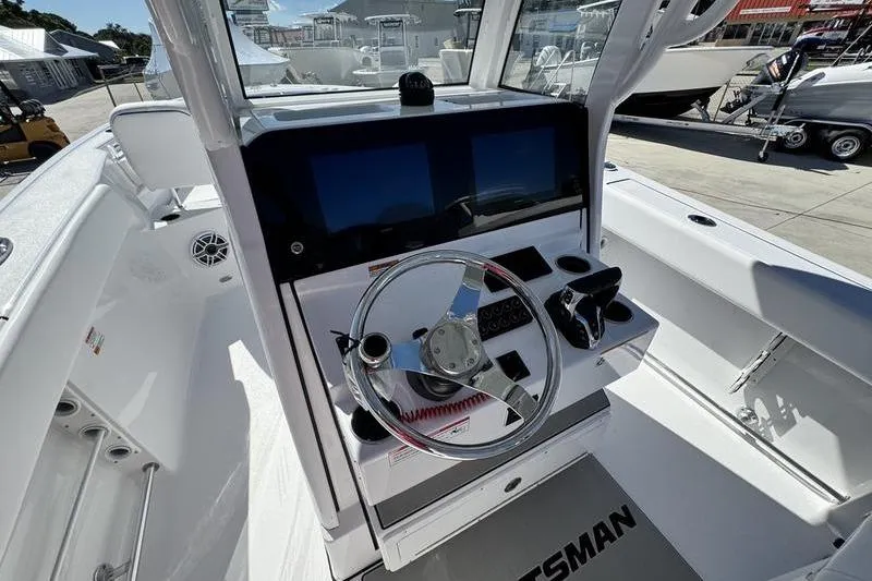 Slide: The Image of 2026 Sportsman Heritage 261 Center Console boat interior with modern steering and dual screens. - 16
