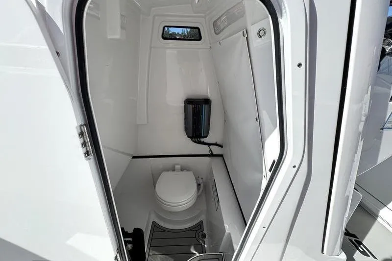Slide: The Image of 2026 Sportsman Heritage 261 Center Console boat interior with compact marine toilet. - 18